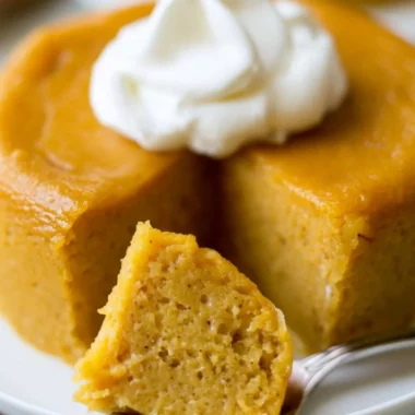 Delicious crustless pumpkin pie pudding served in a bowl with whipped cream.
