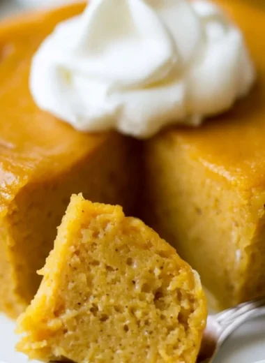 Delicious crustless pumpkin pie pudding served in a bowl with whipped cream.