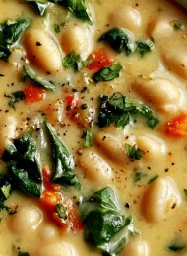 High protein white bean soup in a bowl, garnished with herbs, ready to serve.
