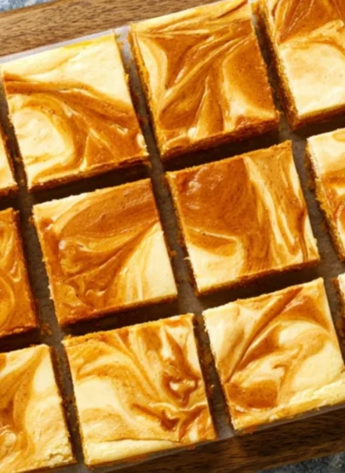 Swirled pumpkin cheesecake bars with a creamy texture and pumpkin topping.