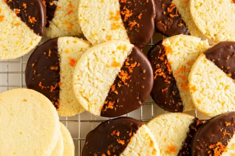 Chocolate dipped orange shortbread cookies on a plate