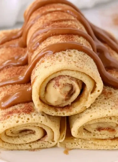 Cinnamon roll protein crepes with a drizzle of icing and cinnamon.