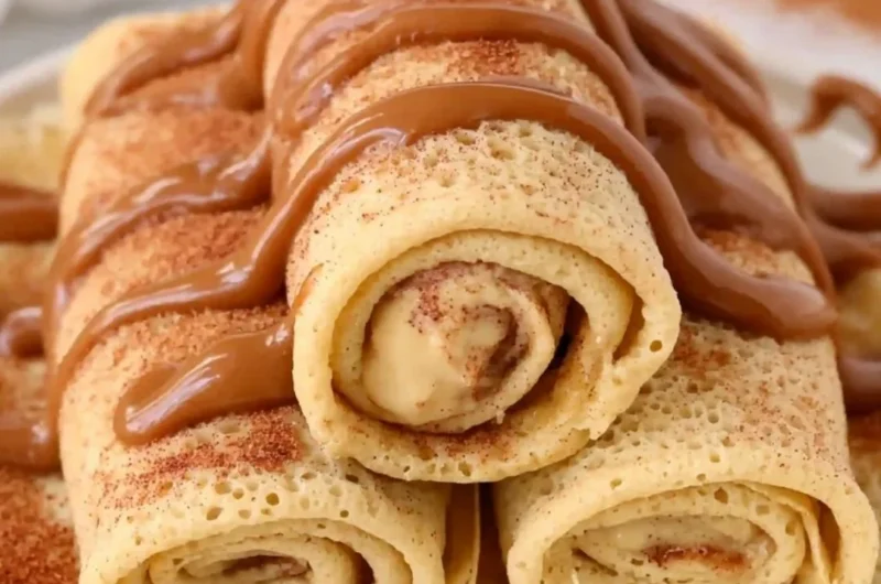 Cinnamon roll protein crepes with a drizzle of icing and cinnamon.