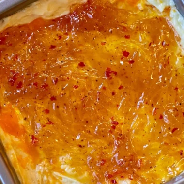 Easy baked Pepper Jelly Cheese Dip served in a dish with crackers