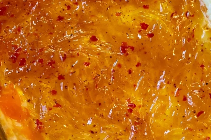 Easy baked Pepper Jelly Cheese Dip served in a dish with crackers