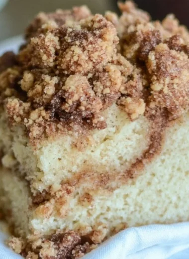 Delicious homemade cinnamon coffee cake served on a plate with coffee.