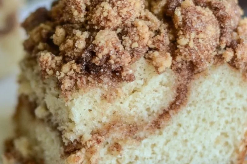 Delicious homemade cinnamon coffee cake served on a plate with coffee.