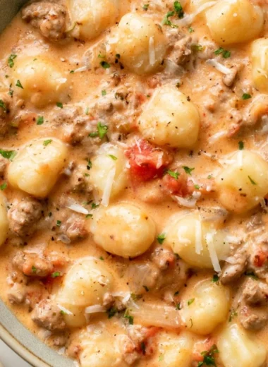 One Pan Ground Beef Gnocchi served in a skillet, topped with fresh herbs.