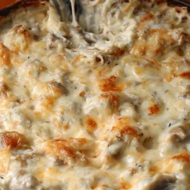 Creamy stuffed mushroom dip in a serving bowl with fresh herbs