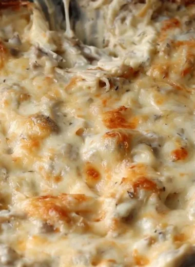 Creamy stuffed mushroom dip in a serving bowl with fresh herbs